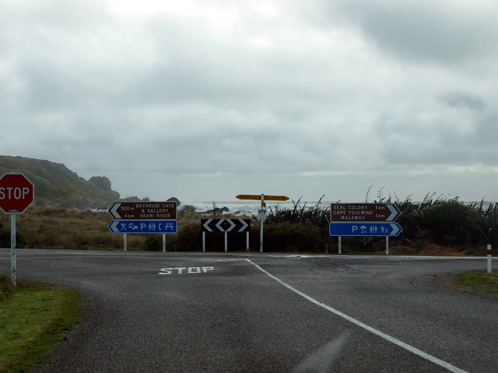 Carrefour et panneaux vers la colonie de phoques et le sentier du cap Foulwind, sous un ciel gris