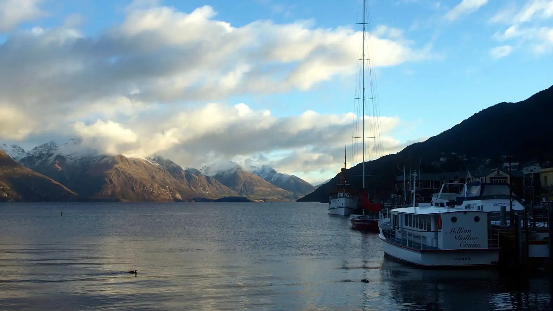Bateaux amarrés au port de Queenstown sur le lac Wakatipu, face aux montagnes enneigées