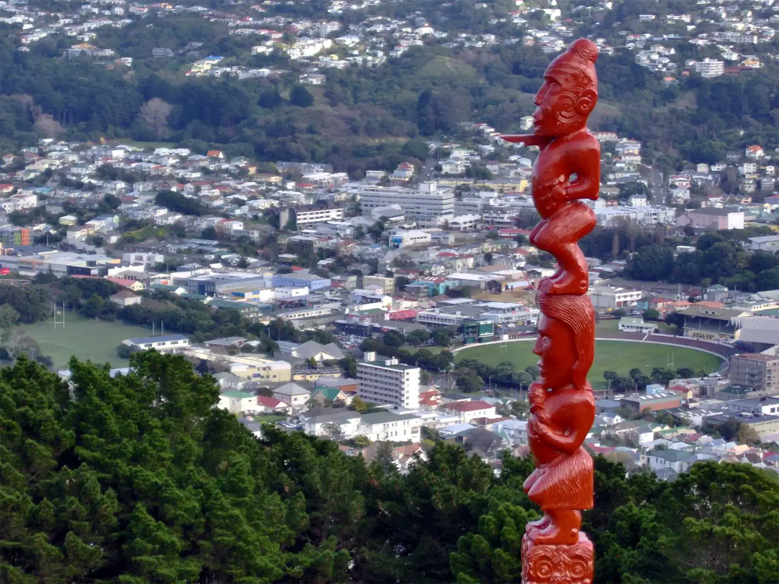 Sculpture maorie rouge dominant les quartiers et un stade ovale de Wellington, vue des hauteurs