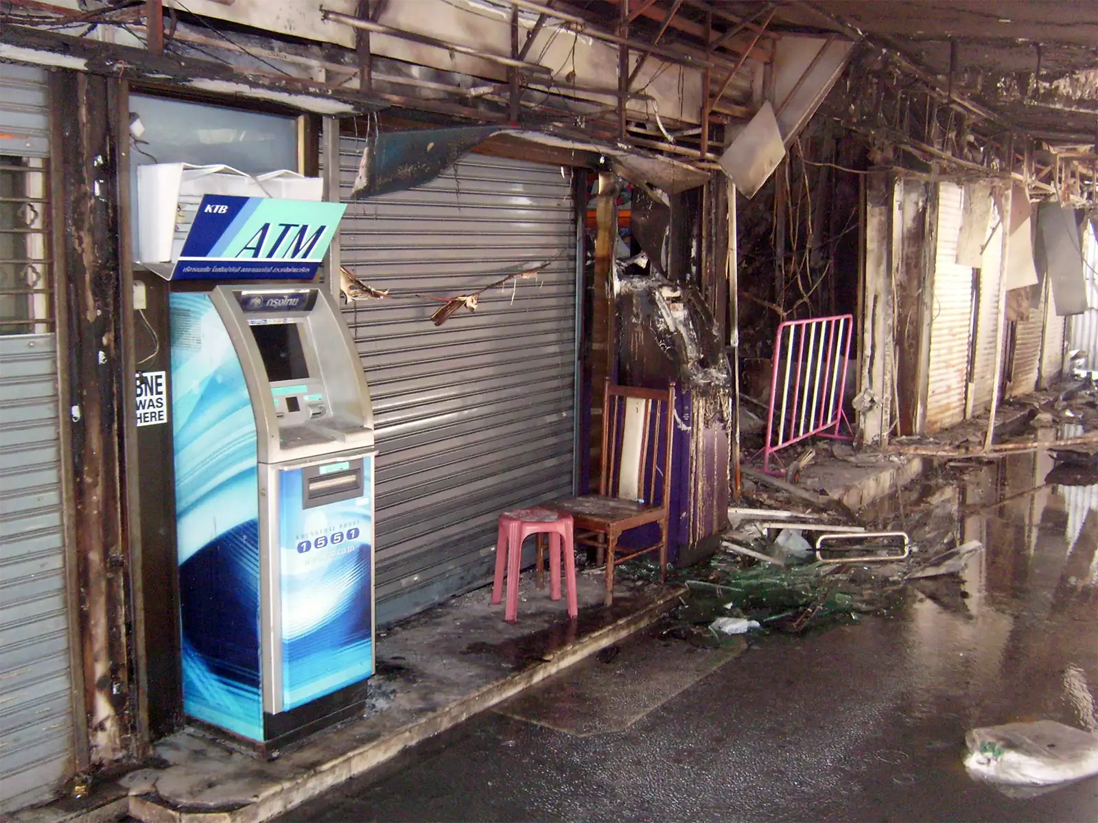 Distributeur de billets intact devant des boutiques brûlées à Ratchaprasong après les émeutes de 2010