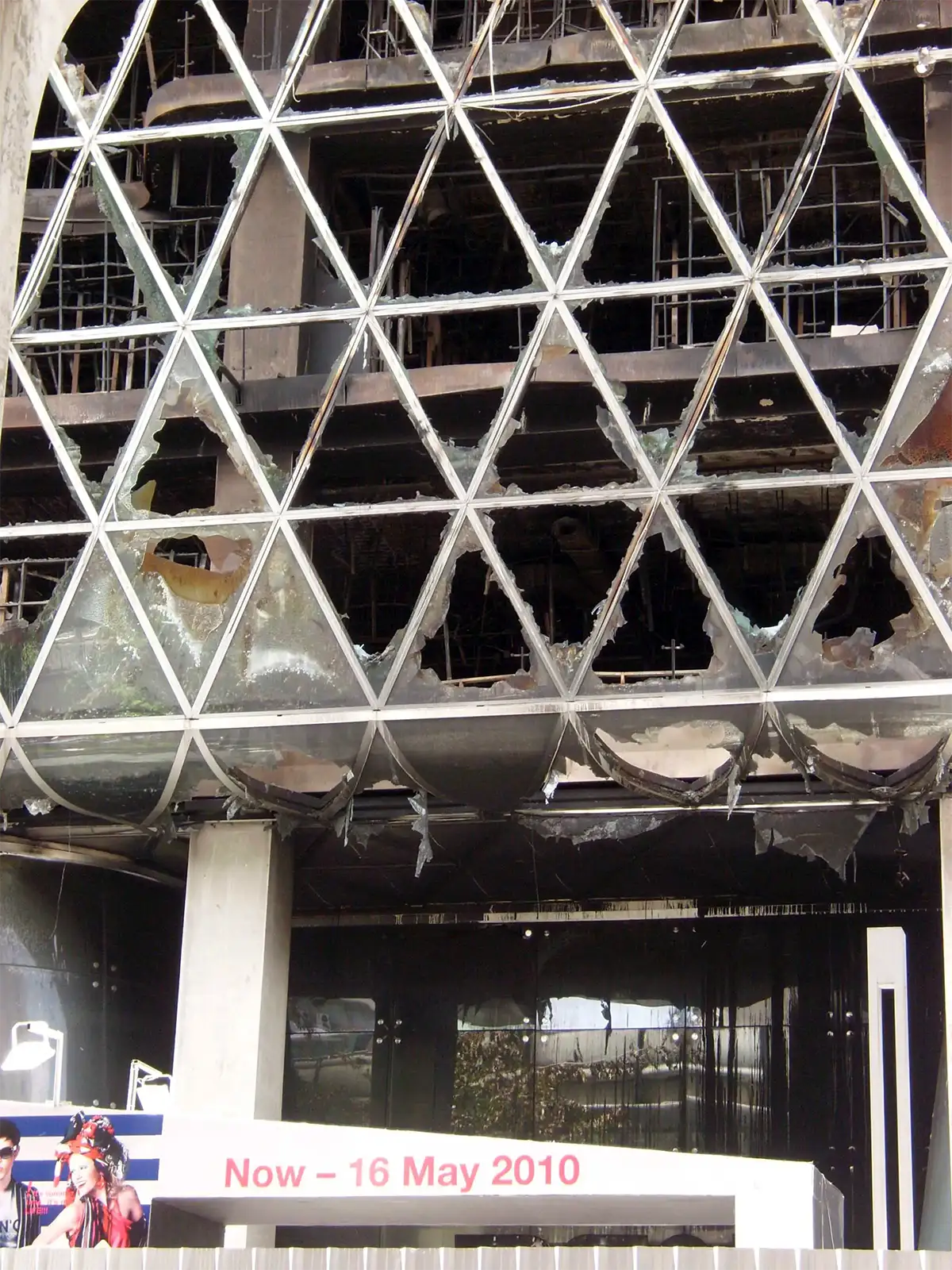 Façade vitrée en triangles éclatée par l’incendie d’un centre commercial de Ratchaprasong