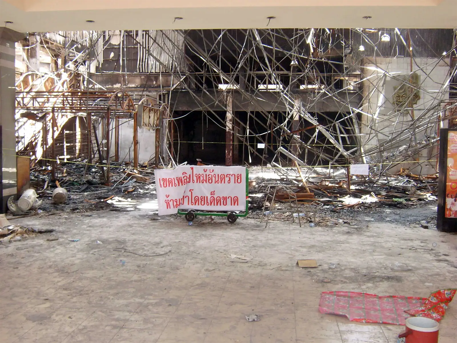 Hall d’un cinéma détruit par l’incendie, avec un panneau d’interdiction en thaï, à Ratchaprasong