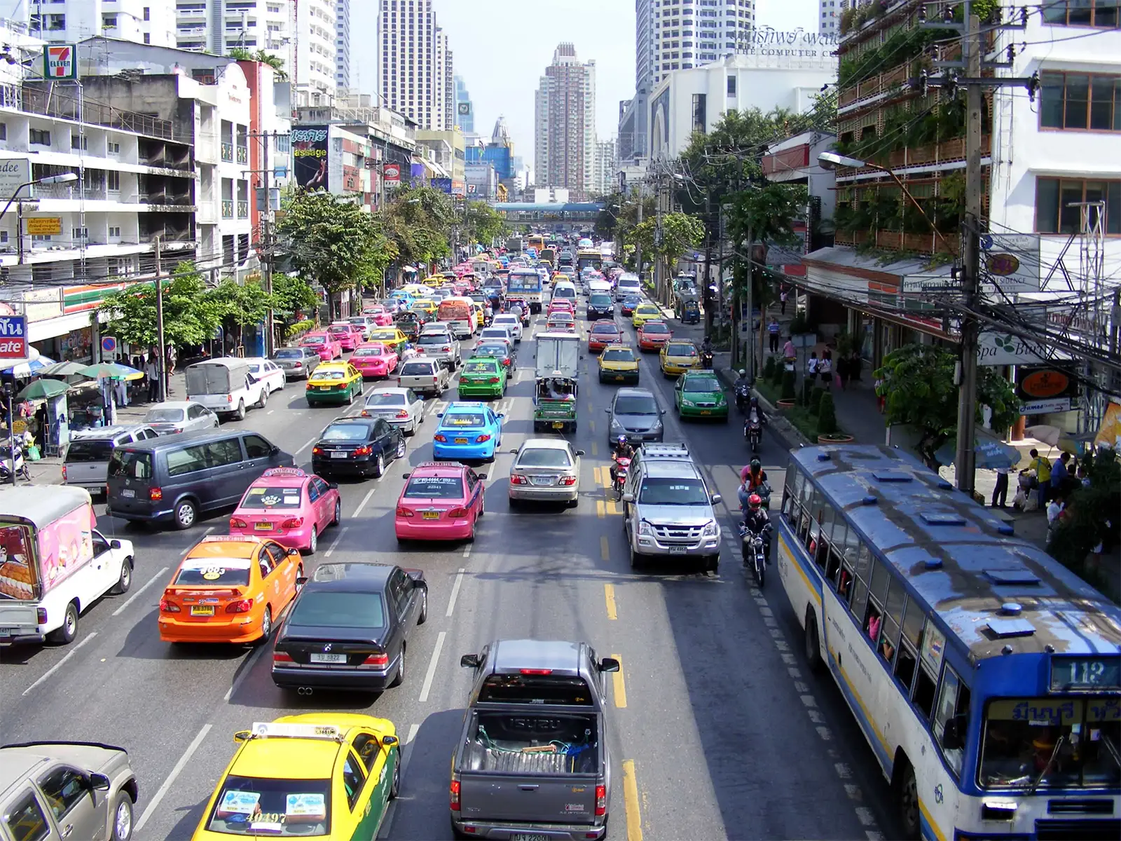 Embouteillage de taxis roses, jaunes et verts sur une grande avenue de Bangkok