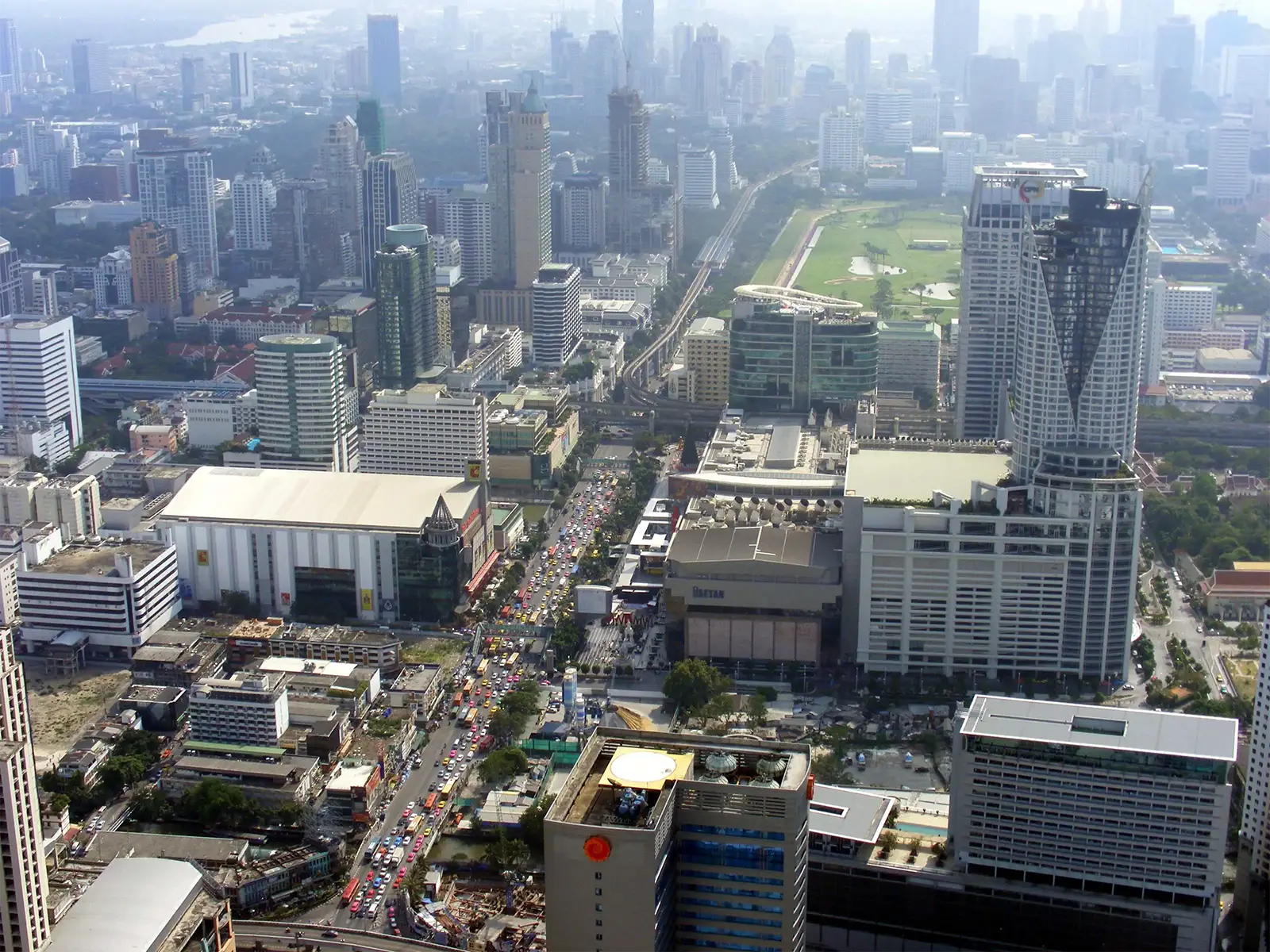 Gratte-ciel, avenues et hippodrome de Bangkok vus du haut d’une tour par temps de brume
