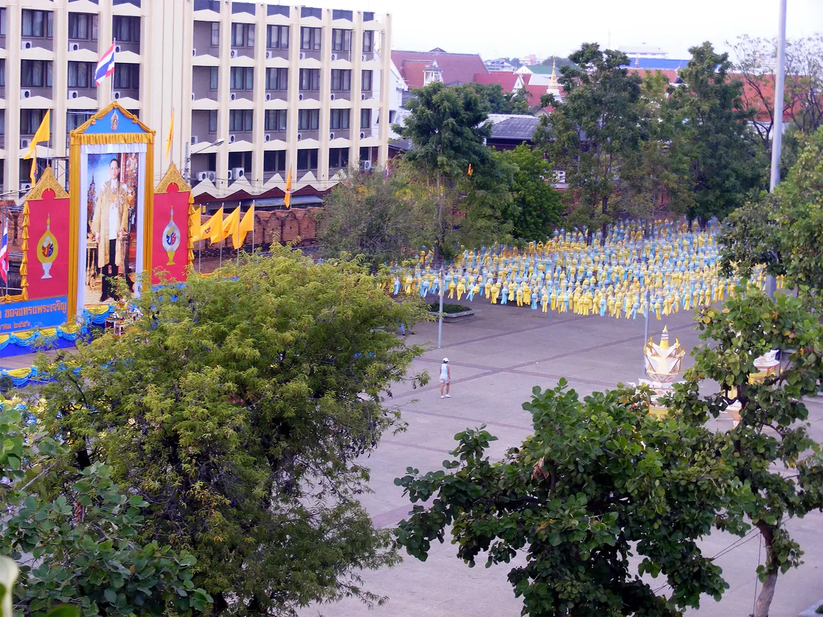 Portrait royal et foule vêtue de jaune rassemblée sur une grande place lors d’une cérémonie, nord de la Thaïlande