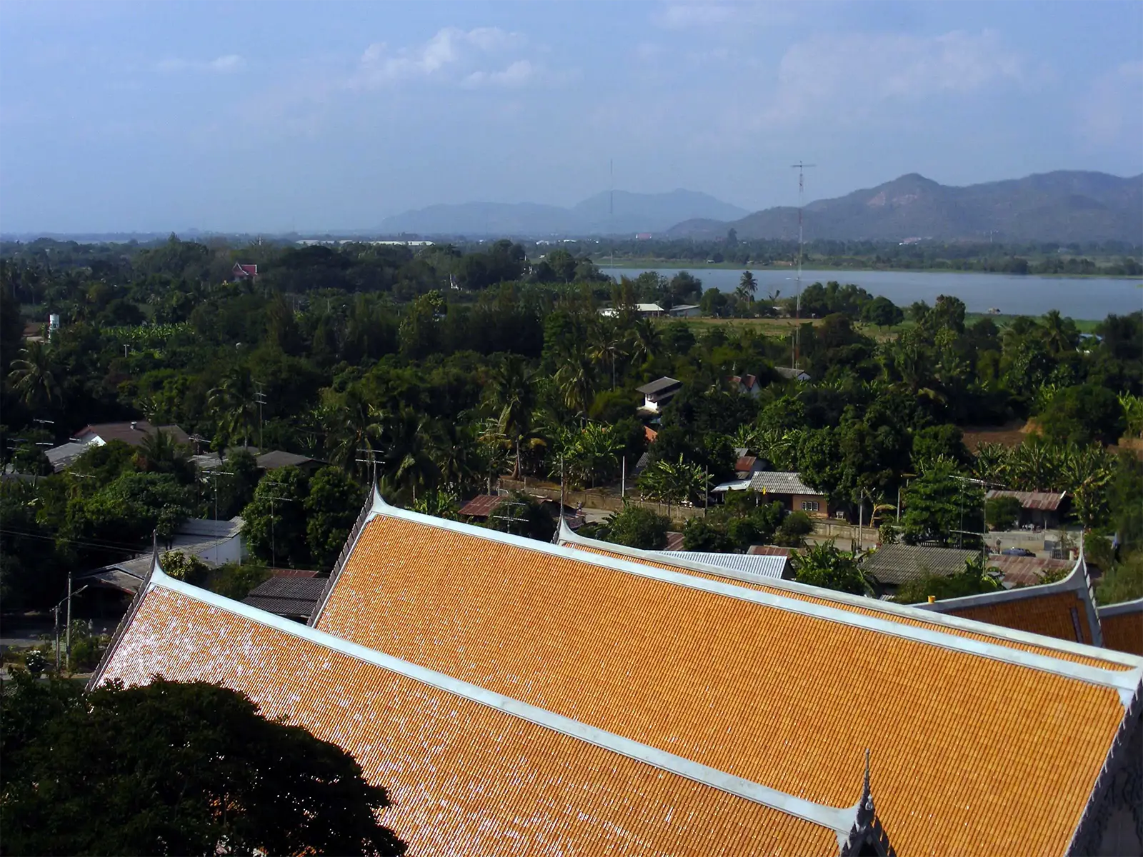 Toits orange d’un temple dominant la campagne verdoyante et un lac près de Kanchanaburi