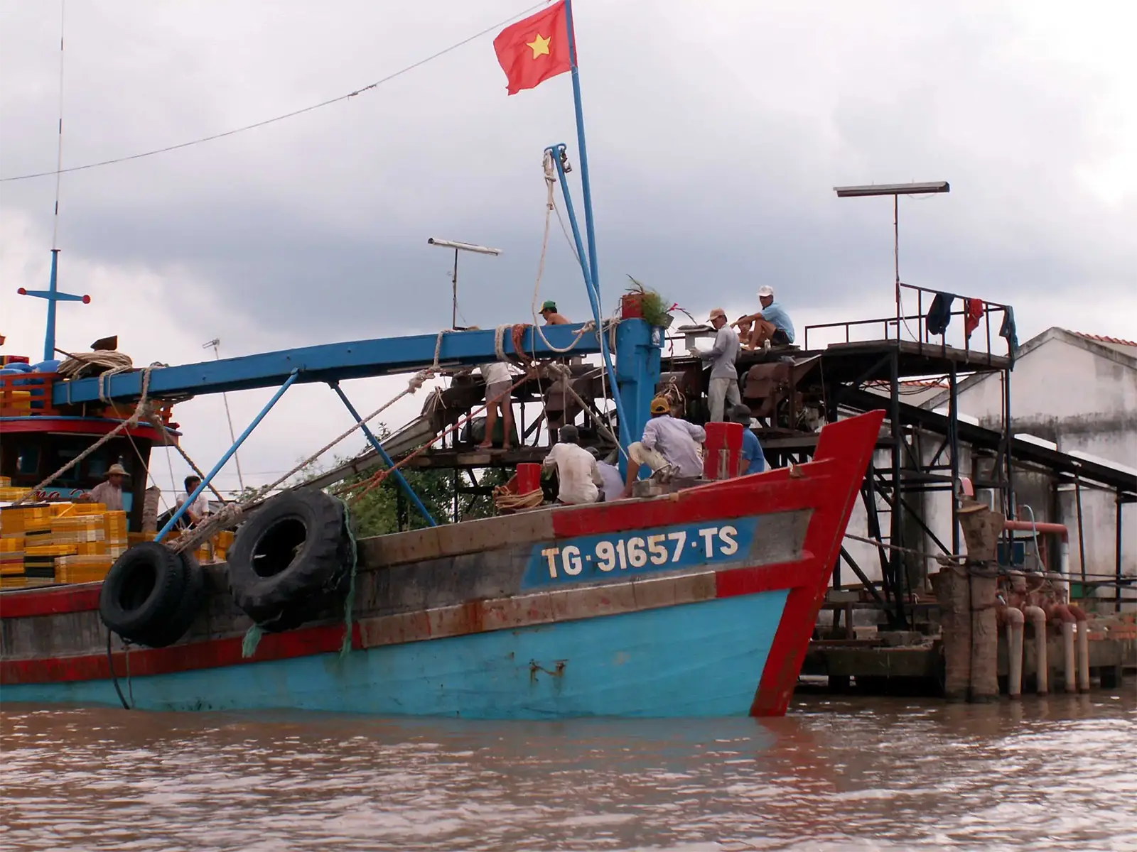 Bateau de marchandises bleu et rouge battant pavillon vietnamien sur un bras du Mékong