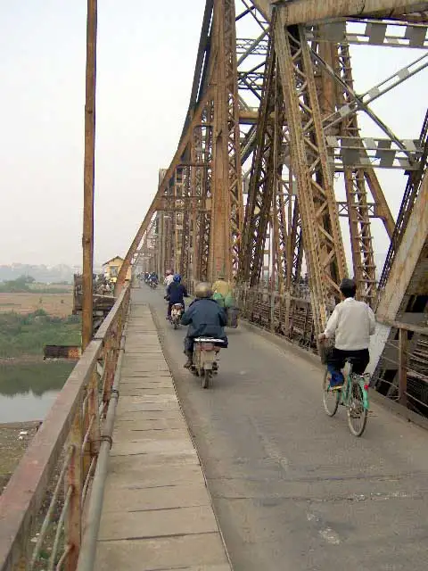 Scooters et cyclistes sur le vieux pont métallique Long Biên à Hanoï