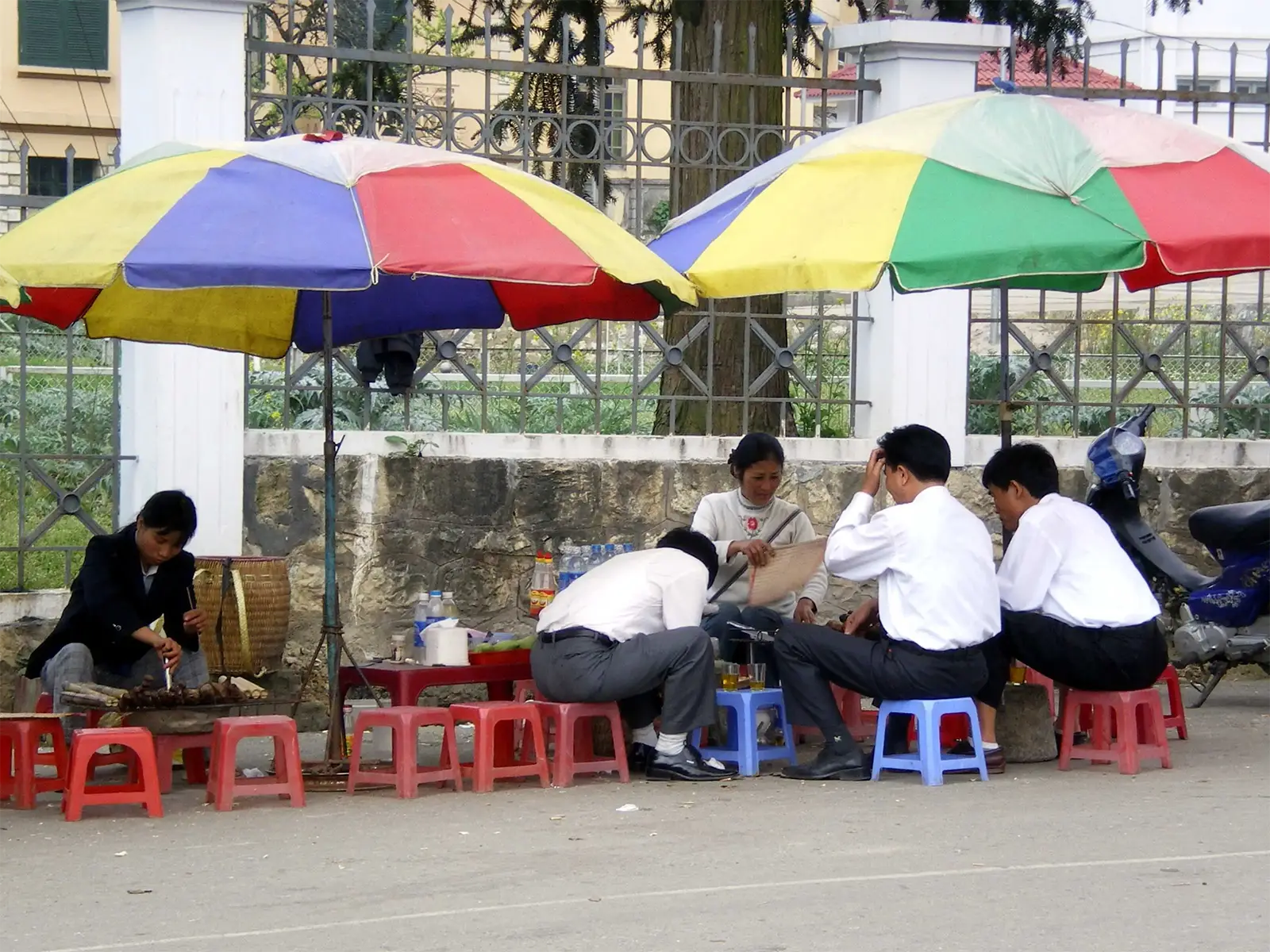 Gargote de rue sous des parasols colorés, avec ses tabourets en plastique, à Sa Pa